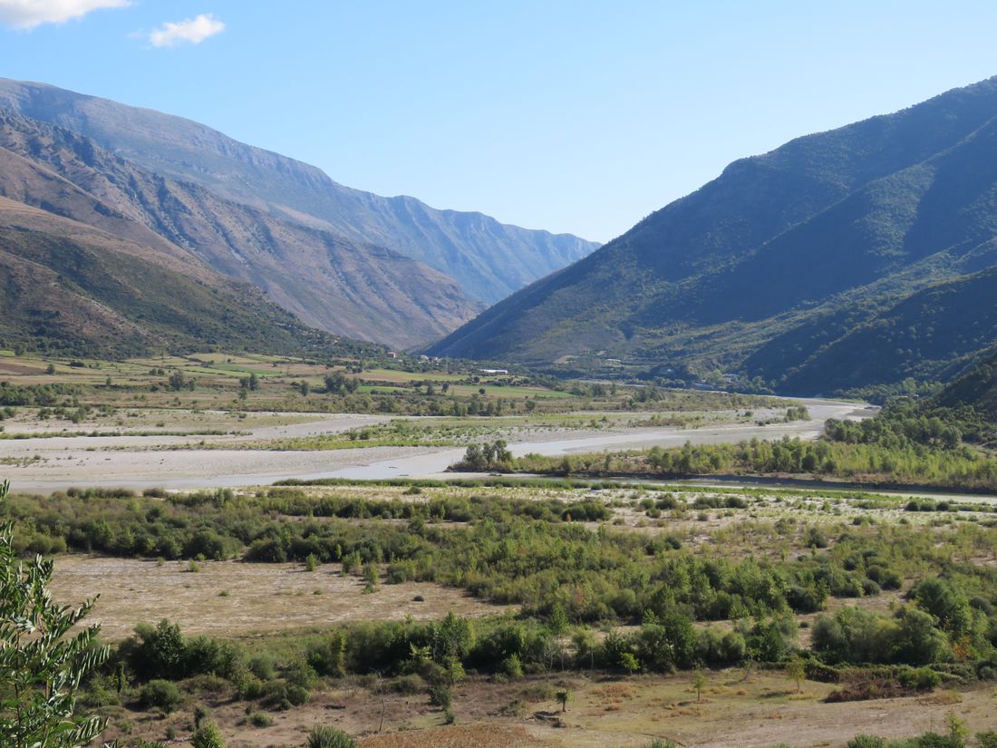 Lugina e gjerë e Vjosës me kanale uji dhe brigje zhavorri pranë Tepelenës